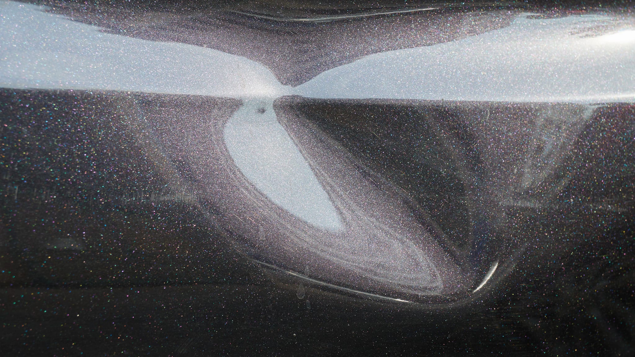 Car Body Dent Image of a black car with a dent that needs repair