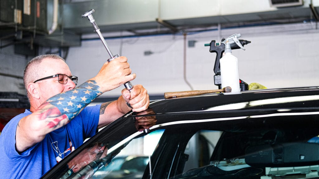 Image of a Conestoga Collision technician performing a paintless dent repair